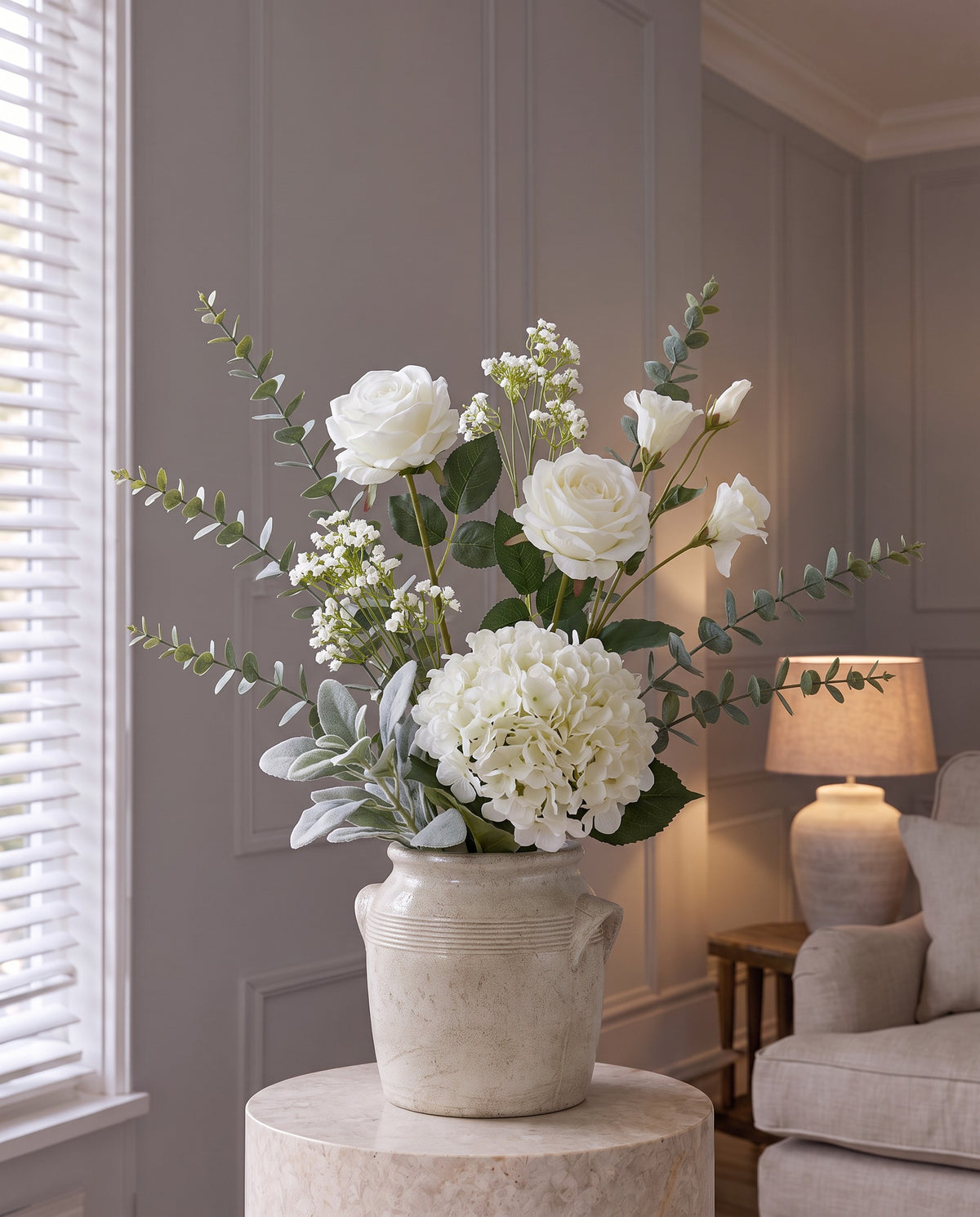 In Loving Memory Sympathy Arrangement: two artificial white roses, a white hydrangea, white lisianthus, gypsophila, eucalyptus and lamb's ear in the cream Tarn Collection Small Pot with handles