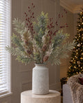 The Bloomville Woodland Hallway Urn: artificial frosted pine, burgundy rosehips, frosted cypress fir and silver wattle in the Bloomville Urn Stone Vase, on a stone plinth in a Christmas living room
