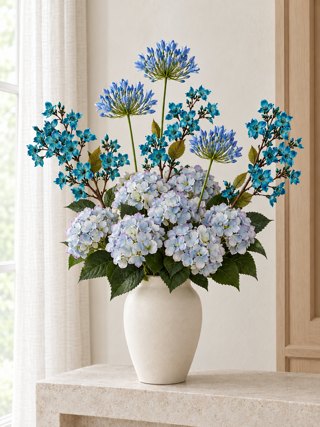 The Delft Blue Bouquet with pale blue hydrangea bunches, blue agapanthus and turquoise-blue Vernicia sprays in a neutral styling vase; vase not included