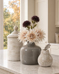 The Kitchen Corner on a marble kitchen island: grey glazed Chive vase with three artificial cafe au lait dahlias at the neck and chocolate chrysanthemums above, the antique white Bayonne cannister and a stone pear