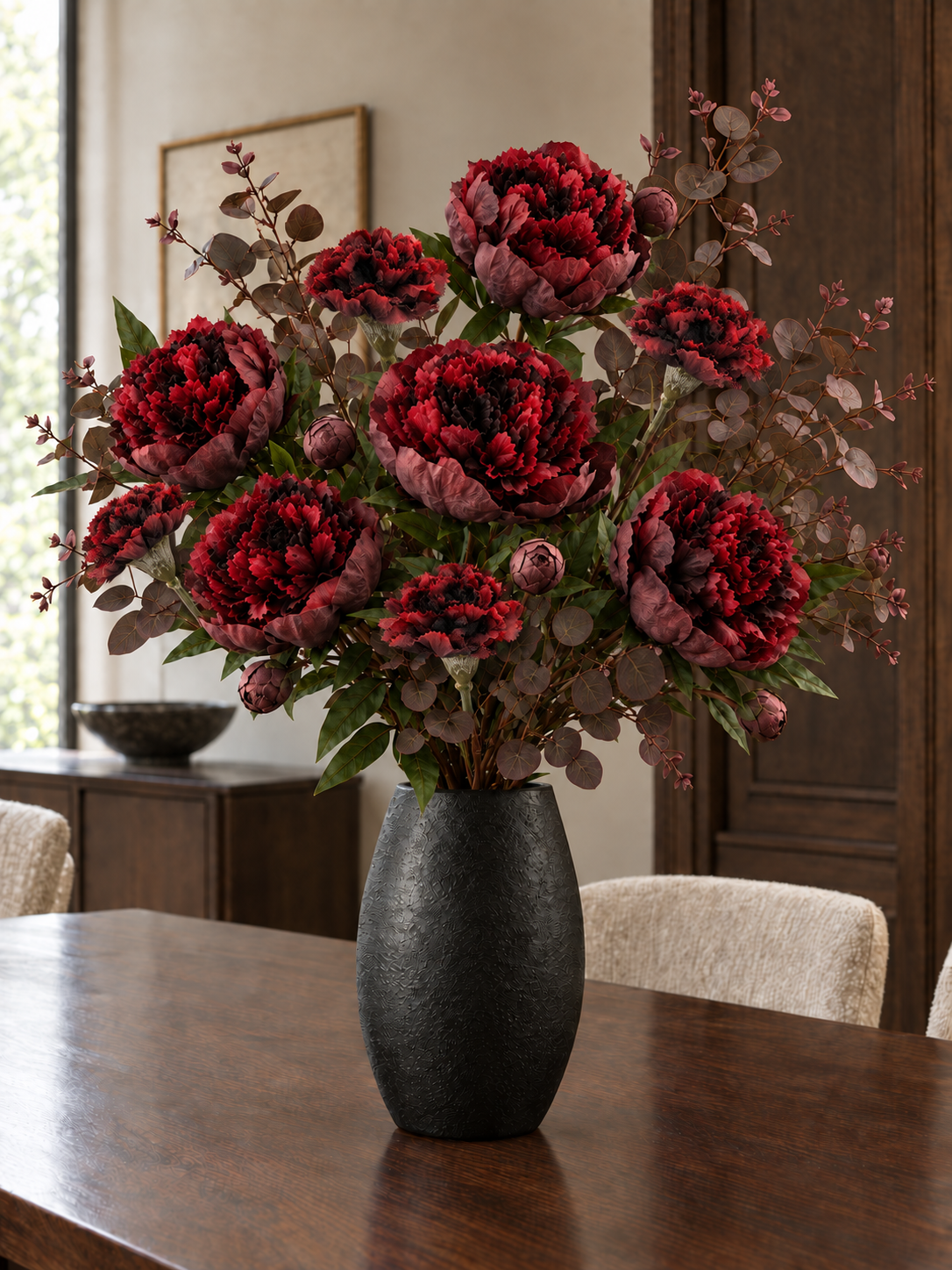 The Nocturne Burgundy Bouquet with burgundy peony flowers and buds, smaller carnations and burgundy eucalyptus in a dark styling vase; vase not included