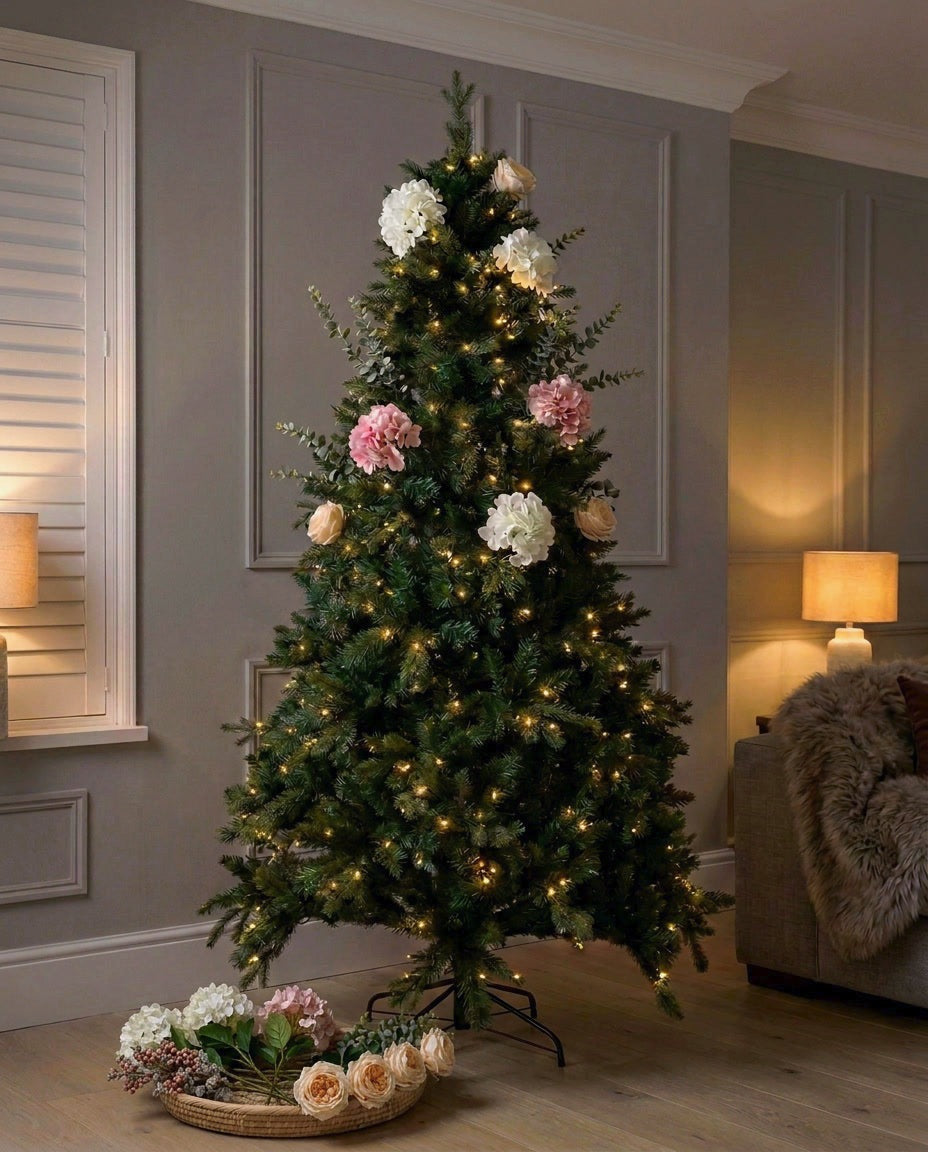 Artificial Winter Bloom flowers only, shown with the 7ft set: a lit tree half dressed with white and pink hydrangeas and blush roses, the remaining stems in a woven basket beside it. Tree and basket not included with Flowers only