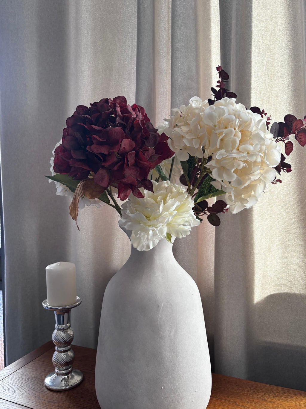 The Darcy Olpe Stone Vase at home with Rachael (@ms._blooms), styled with burgundy and cream hydrangeas by the window. Stems sold separately