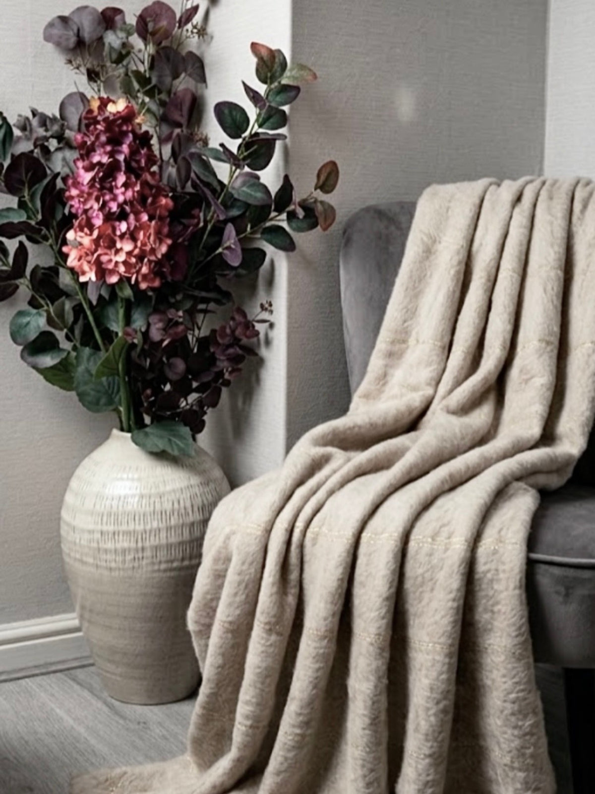 The Kemi Large Olpe Vase beside a chair and throw in Rachael's (@ms._blooms) home. Stems sold separately