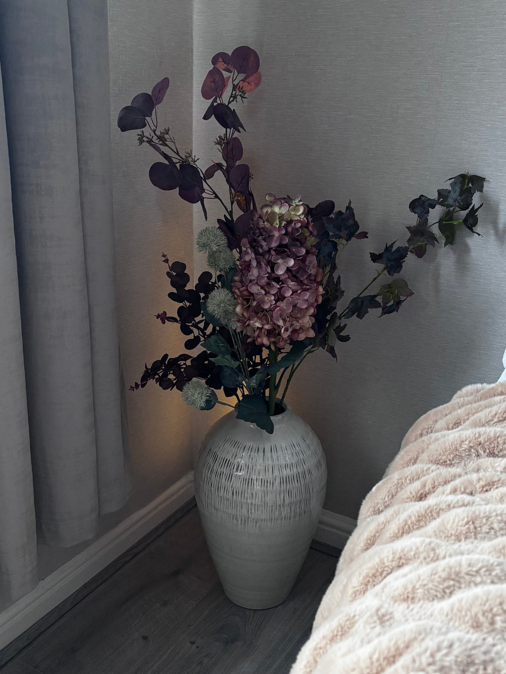 The Kemi Large Olpe Vase at home with Rachael (@ms._blooms), lit by a warm lamp in the evening. Stems sold separately