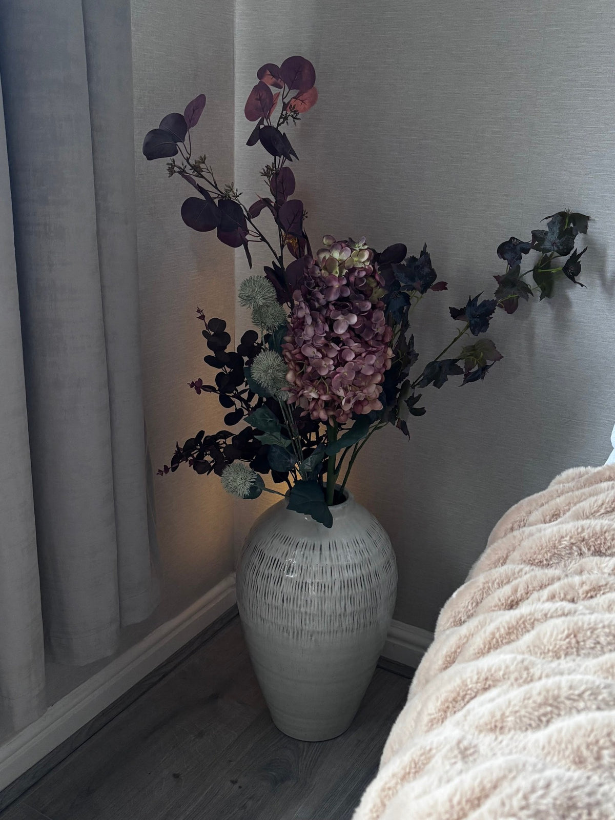 The Kemi Large Olpe Vase at home with Rachael (@ms._blooms), lit by a warm lamp in the evening. Stems sold separately